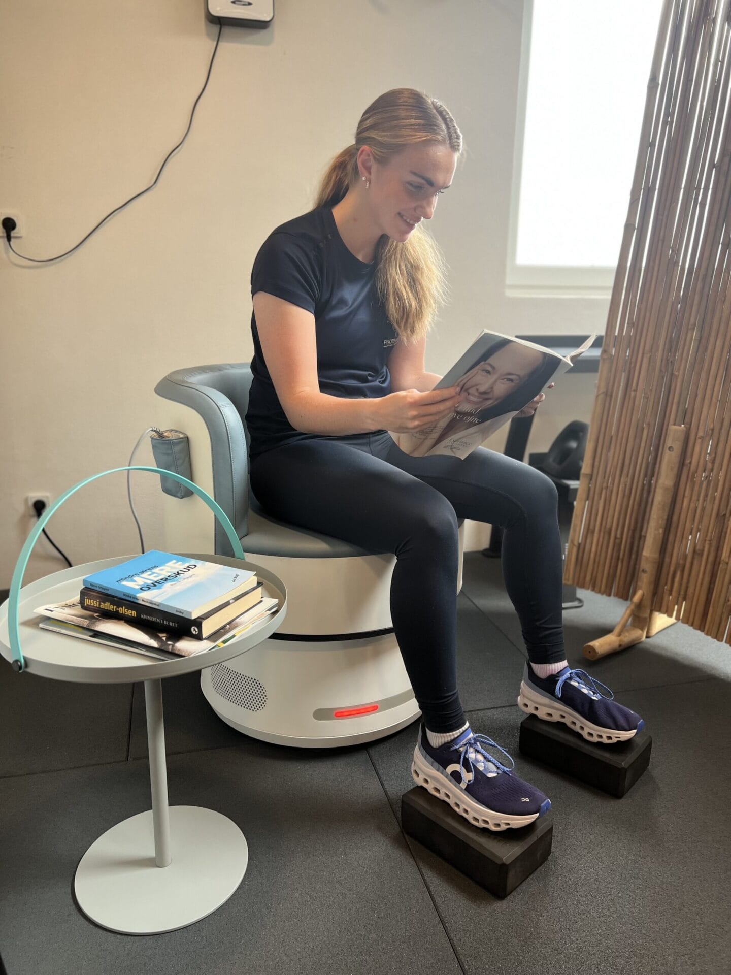 Kvinde sidder og læser magasin i klinik